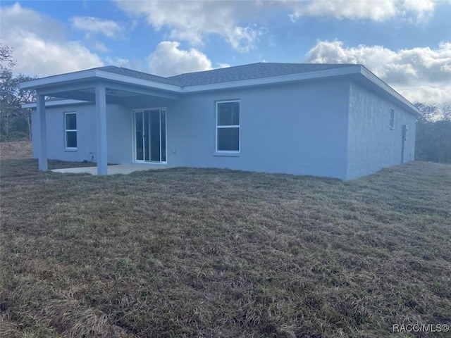 rear view of house with a yard and a patio