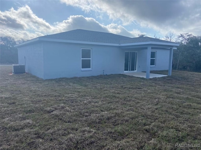 rear view of house featuring a yard, a patio, and central air condition unit