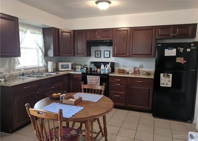 kitchen featuring sink, range with electric stovetop, black refrigerator, light tile patterned floors, and dark brown cabinets