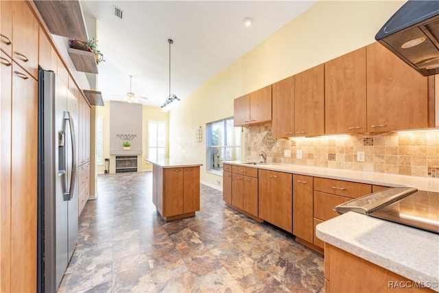 kitchen featuring sink, ceiling fan, custom range hood, a kitchen island, and stainless steel fridge with ice dispenser