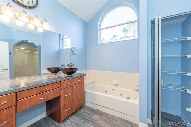 bathroom with vanity, lofted ceiling, and shower with separate bathtub