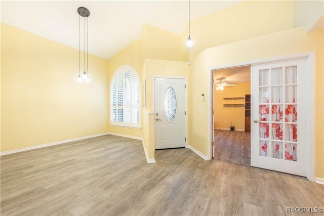 foyer entrance with hardwood / wood-style flooring, vaulted ceiling, and ceiling fan