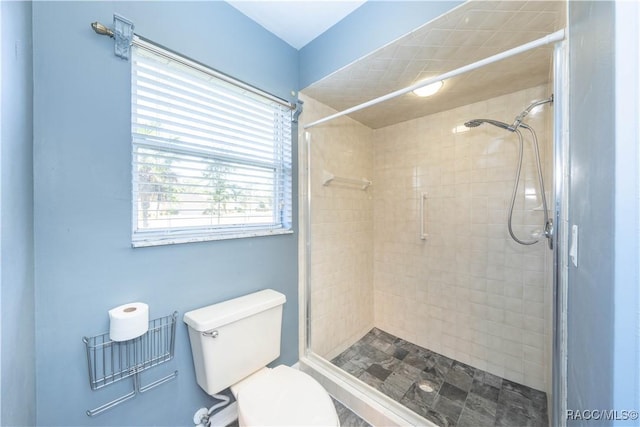 bathroom featuring toilet and tiled shower