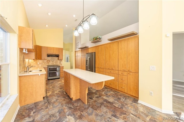 kitchen with tasteful backsplash, stainless steel appliances, sink, decorative light fixtures, and a kitchen island