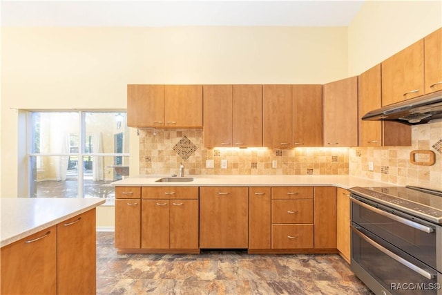 kitchen with decorative backsplash, sink, stainless steel range with electric cooktop, and a high ceiling