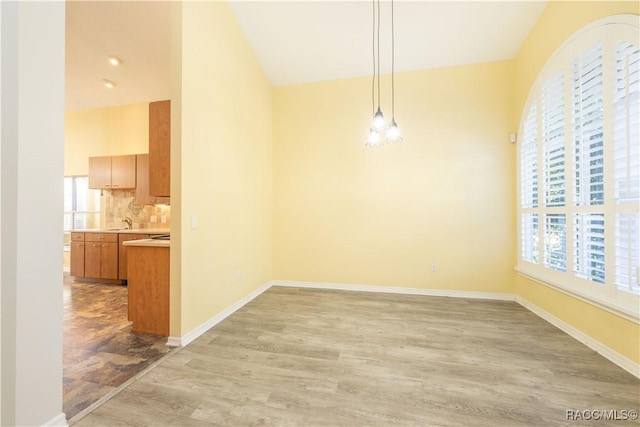 unfurnished dining area with plenty of natural light, sink, and light hardwood / wood-style flooring