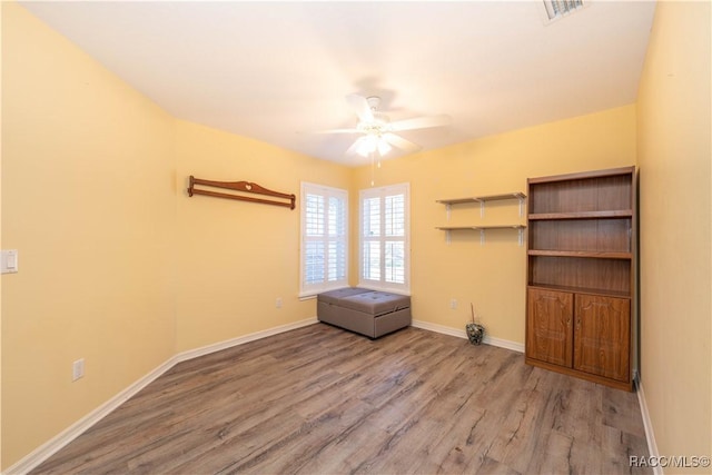 empty room featuring hardwood / wood-style floors and ceiling fan