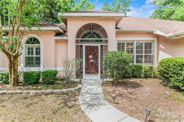 7690 N Greendale Dr, Citrus Springs, FL 34434 - property entrance with stucco siding and roof with shingles