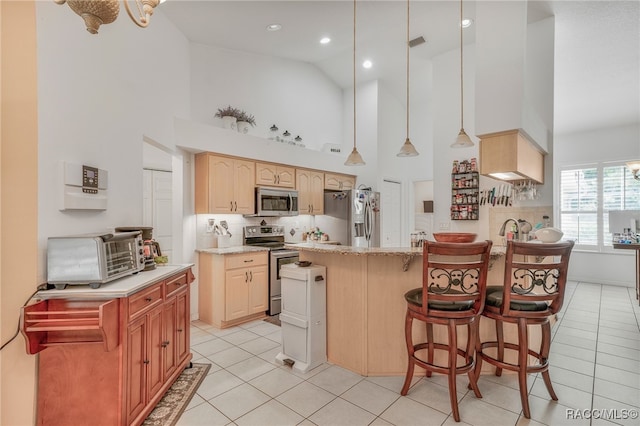 7690 N Greendale Dr, Citrus Springs, FL 34434 - kitchen featuring appliances with stainless steel finishes, high vaulted ceiling, light tile patterned floors, a kitchen bar, and a peninsula