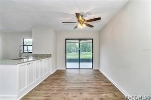 interior space featuring ceiling fan, white cabinets, and light wood-type flooring