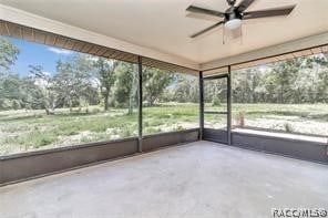 unfurnished sunroom with ceiling fan