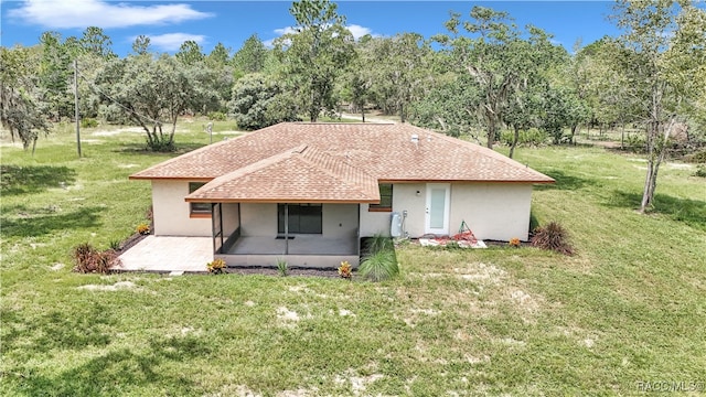 back of house with a patio area and a lawn