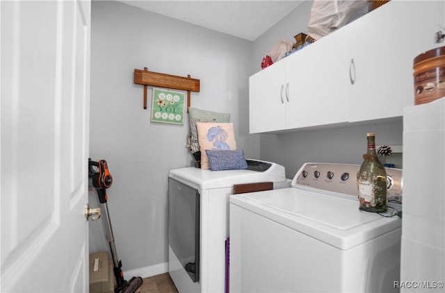 laundry room with separate washer and dryer and cabinets