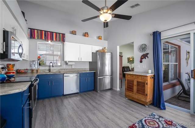 kitchen featuring ceiling fan, white cabinetry, stainless steel appliances, blue cabinets, and light wood-type flooring