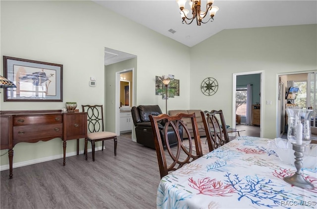 bedroom featuring an inviting chandelier, high vaulted ceiling, and hardwood / wood-style floors