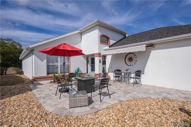 back of property with a patio area and an outdoor fire pit