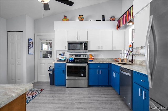 kitchen with sink, blue cabinetry, appliances with stainless steel finishes, white cabinetry, and light wood-type flooring