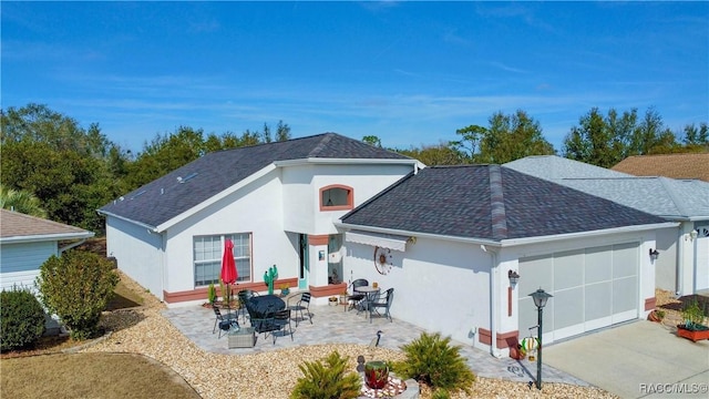 back of property featuring a garage and a patio area