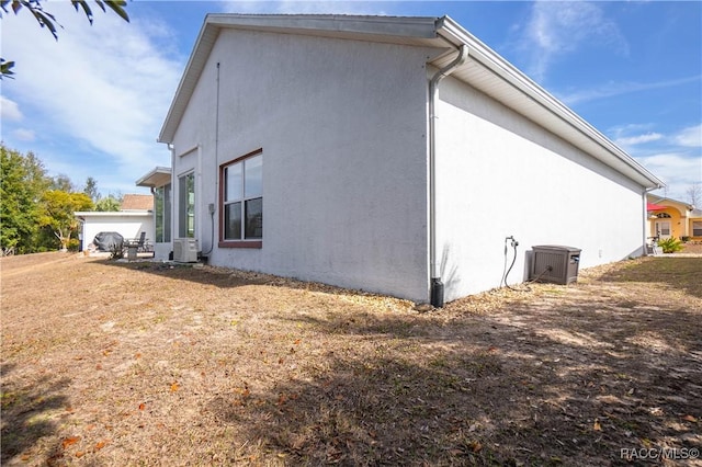 view of side of property featuring a yard and central air condition unit