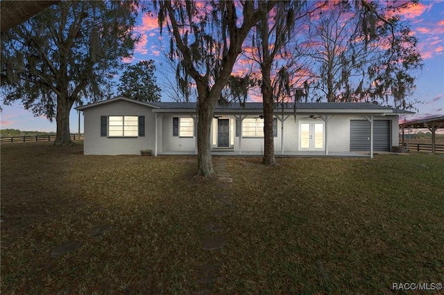 view of front facade featuring fence, a front lawn, and stucco siding