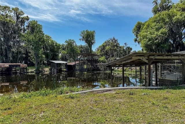 dock area featuring a water view and a lawn