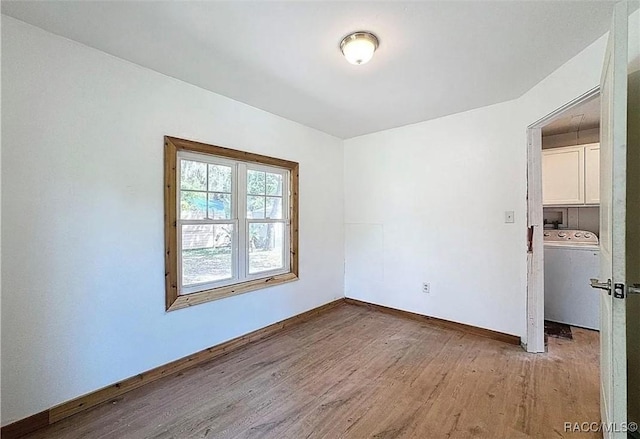 unfurnished room featuring washer / dryer and light hardwood / wood-style flooring