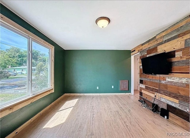 living room with light wood-type flooring and wooden walls