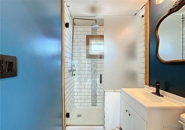 bathroom with vanity, toilet, and a shower with shower door