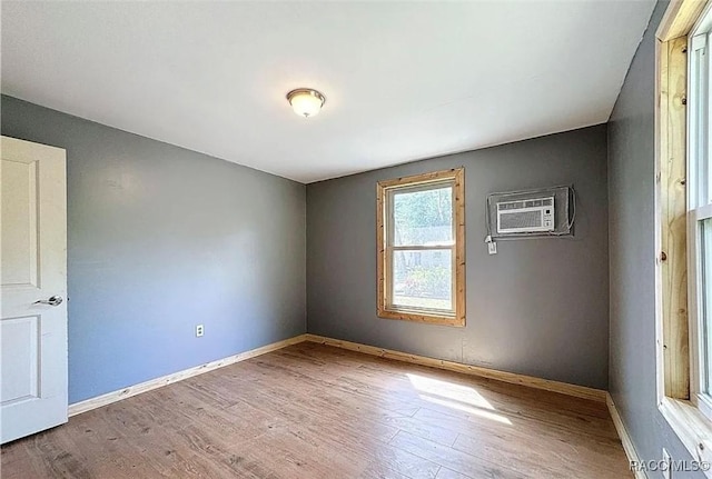 empty room with a wall mounted air conditioner and wood-type flooring