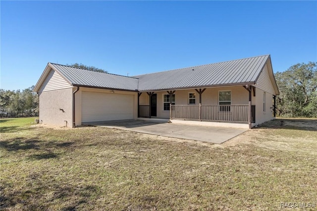 view of front of property featuring a front yard, a garage, and covered porch