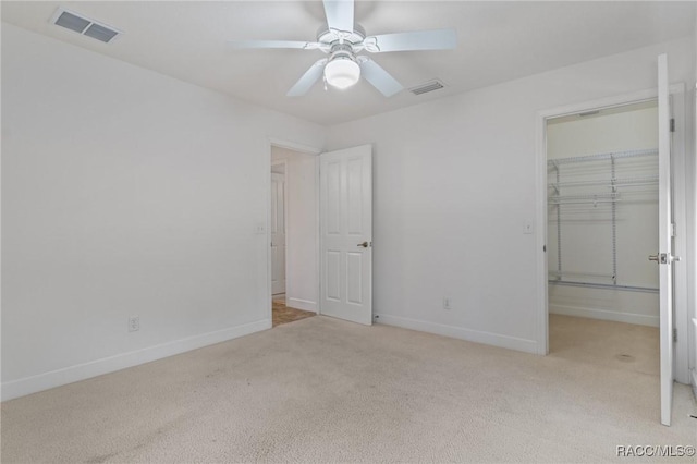 unfurnished bedroom with a closet, light carpet, and ceiling fan