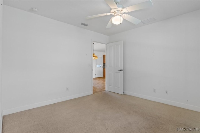 spare room with ceiling fan and light carpet