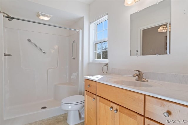 bathroom with walk in shower, vanity, and toilet