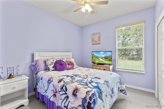 carpeted bedroom featuring multiple windows, ceiling fan, and a closet