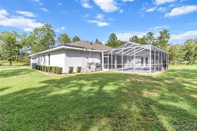 rear view of property with a lawn and glass enclosure