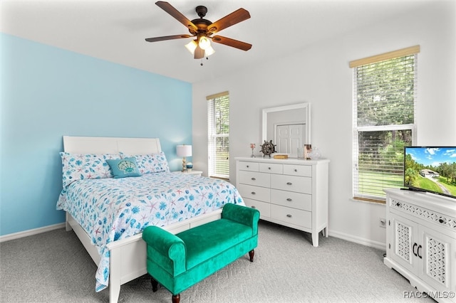 carpeted bedroom with multiple windows and ceiling fan