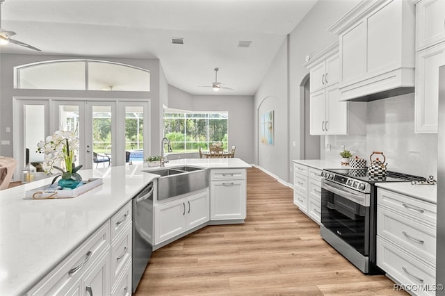 kitchen with sink, french doors, appliances with stainless steel finishes, white cabinets, and light wood-type flooring