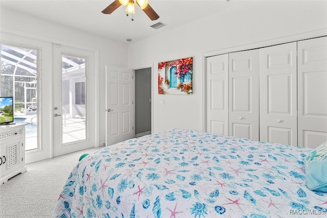 bedroom featuring light carpet, access to outside, french doors, ceiling fan, and a closet