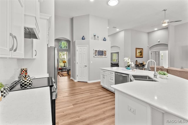 kitchen with appliances with stainless steel finishes, ceiling fan, sink, light hardwood / wood-style flooring, and white cabinets