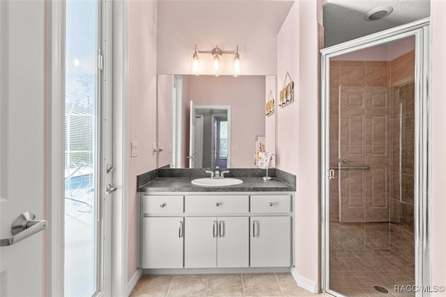 bathroom featuring tile patterned flooring, vanity, and a shower with door