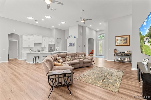 living room with ceiling fan and light hardwood / wood-style flooring