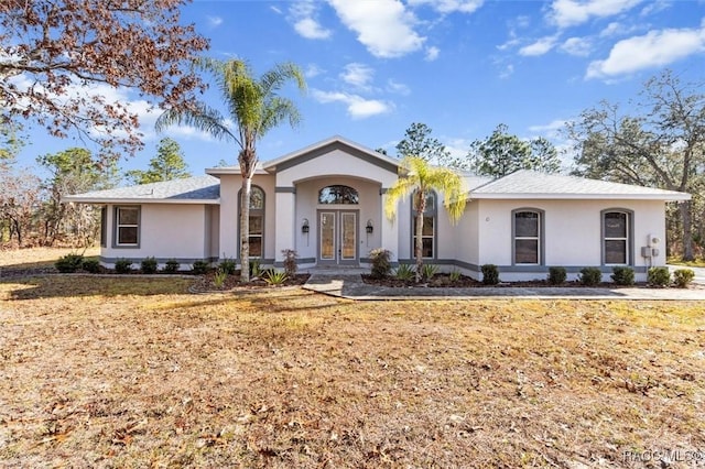 ranch-style home featuring a front lawn and french doors