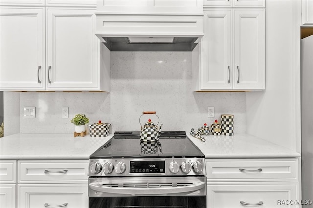 4340 W Mustang Blvd, Beverly Hills, FL 34465 - kitchen featuring stainless steel electric stove, white cabinetry, light countertops, custom exhaust hood, and tasteful backsplash