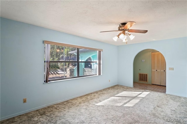 unfurnished room featuring a textured ceiling, light colored carpet, and ceiling fan