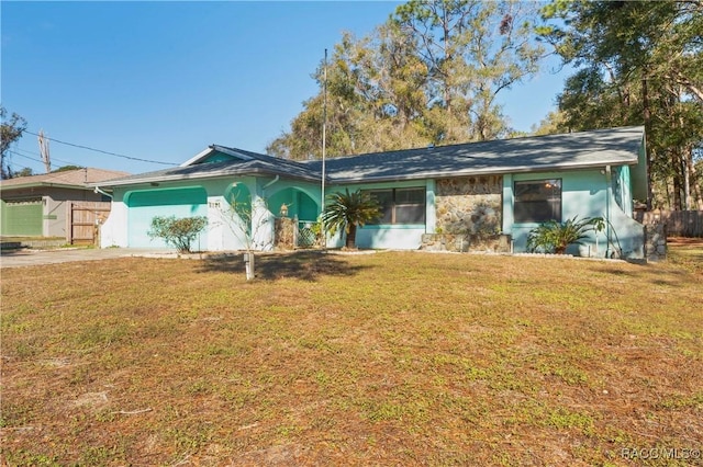 ranch-style house featuring a garage and a front lawn