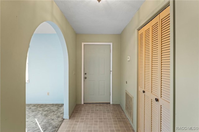 doorway to outside featuring a textured ceiling