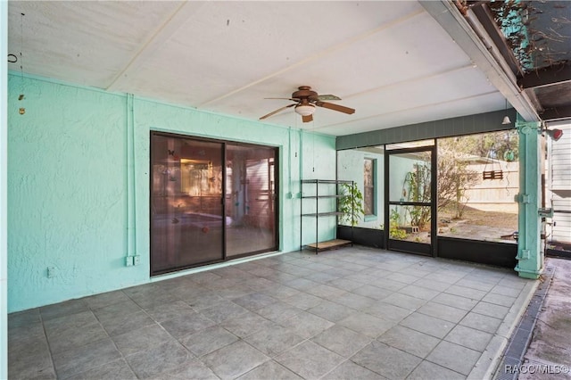 unfurnished sunroom with ceiling fan