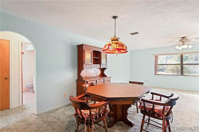 dining space featuring ceiling fan, carpet, and a textured ceiling