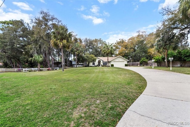 view of home's community featuring a garage, driveway, a yard, and fence