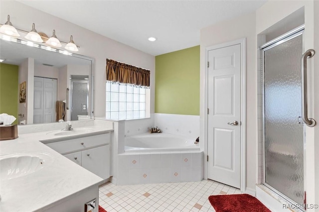 full bathroom featuring double vanity, a stall shower, tile patterned flooring, and a sink